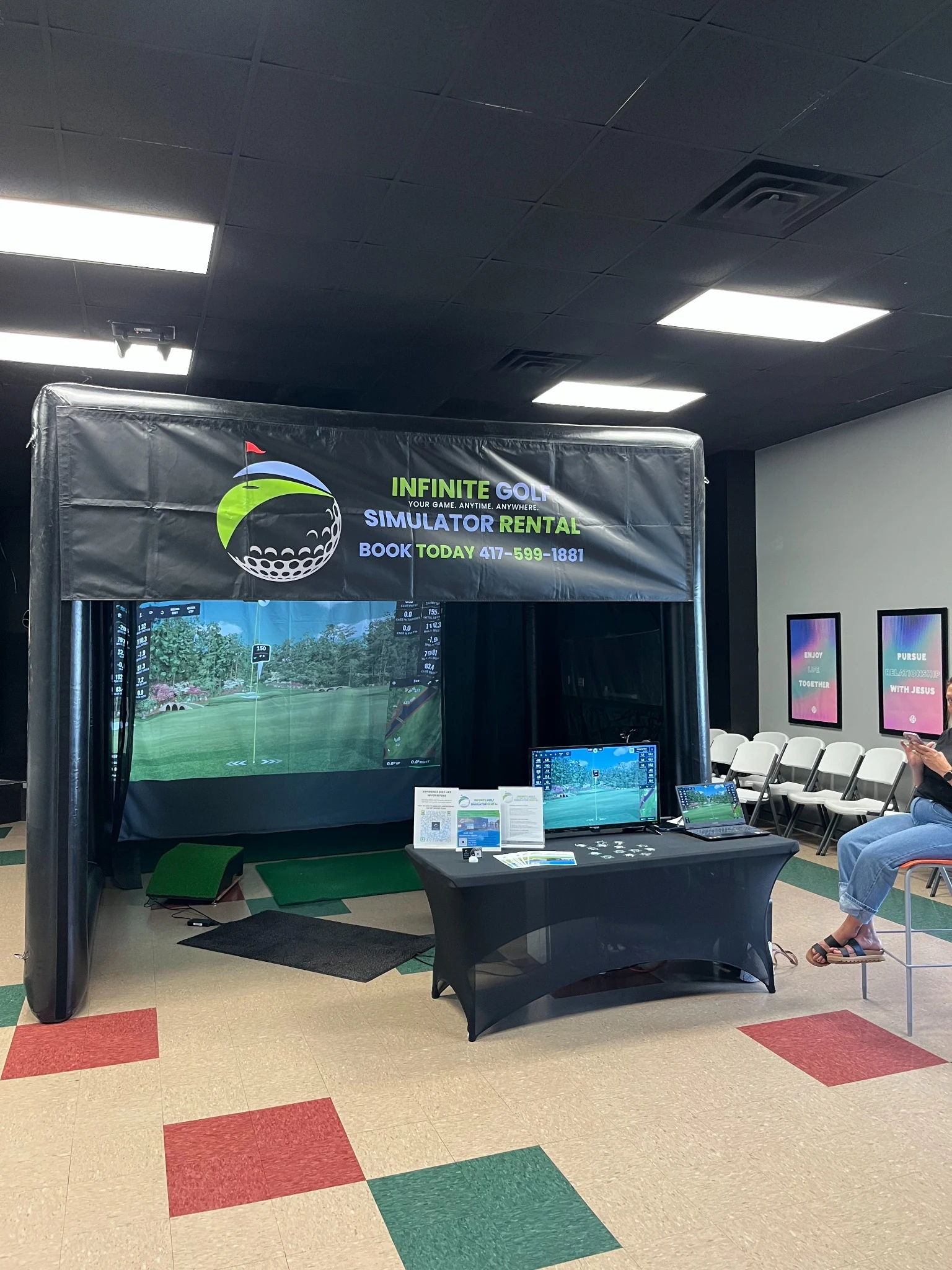 Infinite Golf simulator display booth at an indoor event