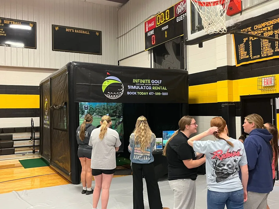 Students gathered around the Infinite Golf simulator during the Fair Play High School Lock-In
